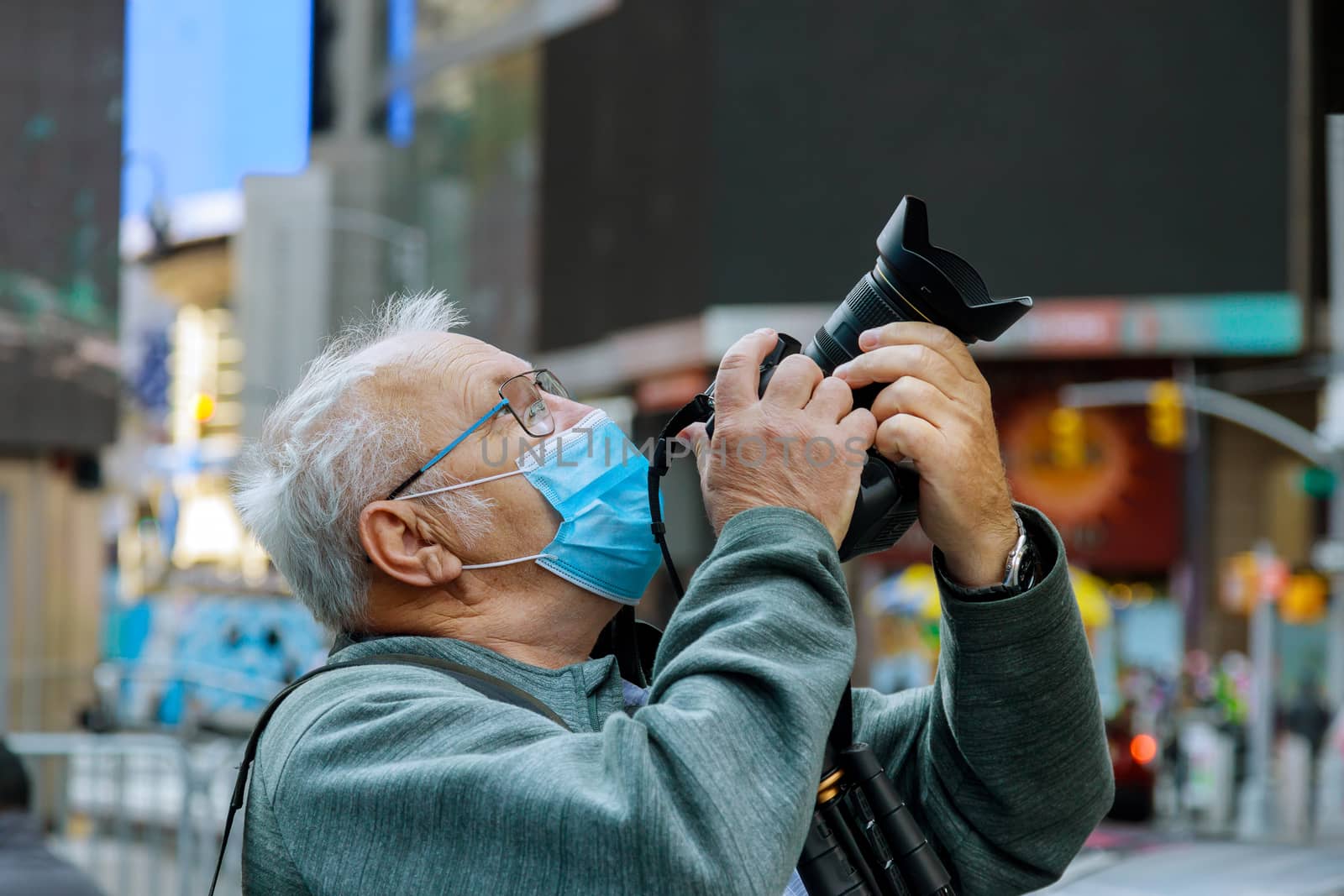 New normal tourism man in a mask takes pictures of New York travel city tour during summer holidays after lockdown USA