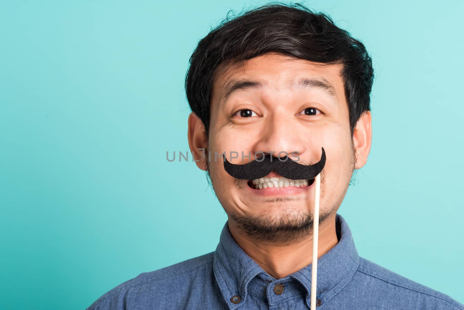 handsome man holding funny mustache card on his mouth by Sorapop