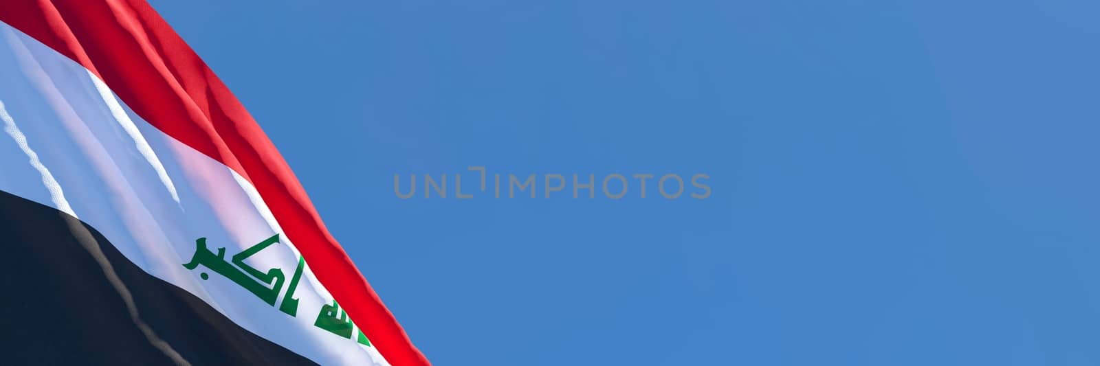 3D rendering of the national flag of Iraq waving in the wind against a blue sky