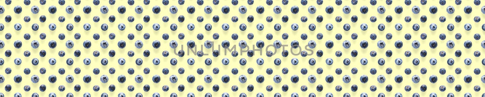Background of Freshly picked blueberries on yellow backdrop. Blackberry modern flatlay background.