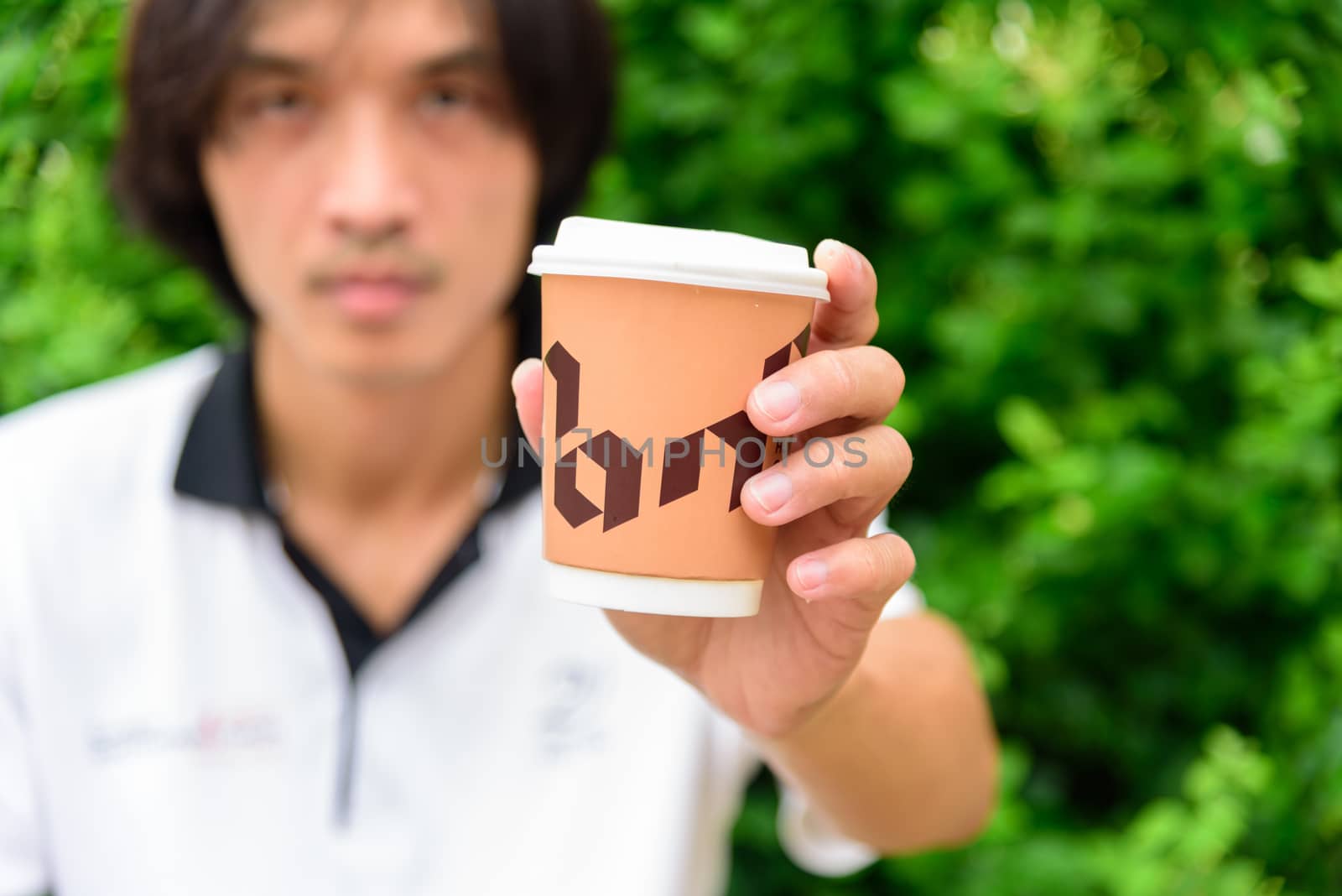 Bangkok, Thailand - 16 September, 2020:  The man hand show a cup of hot coffee of NANA Hunter Coffee Roasters coffee brand