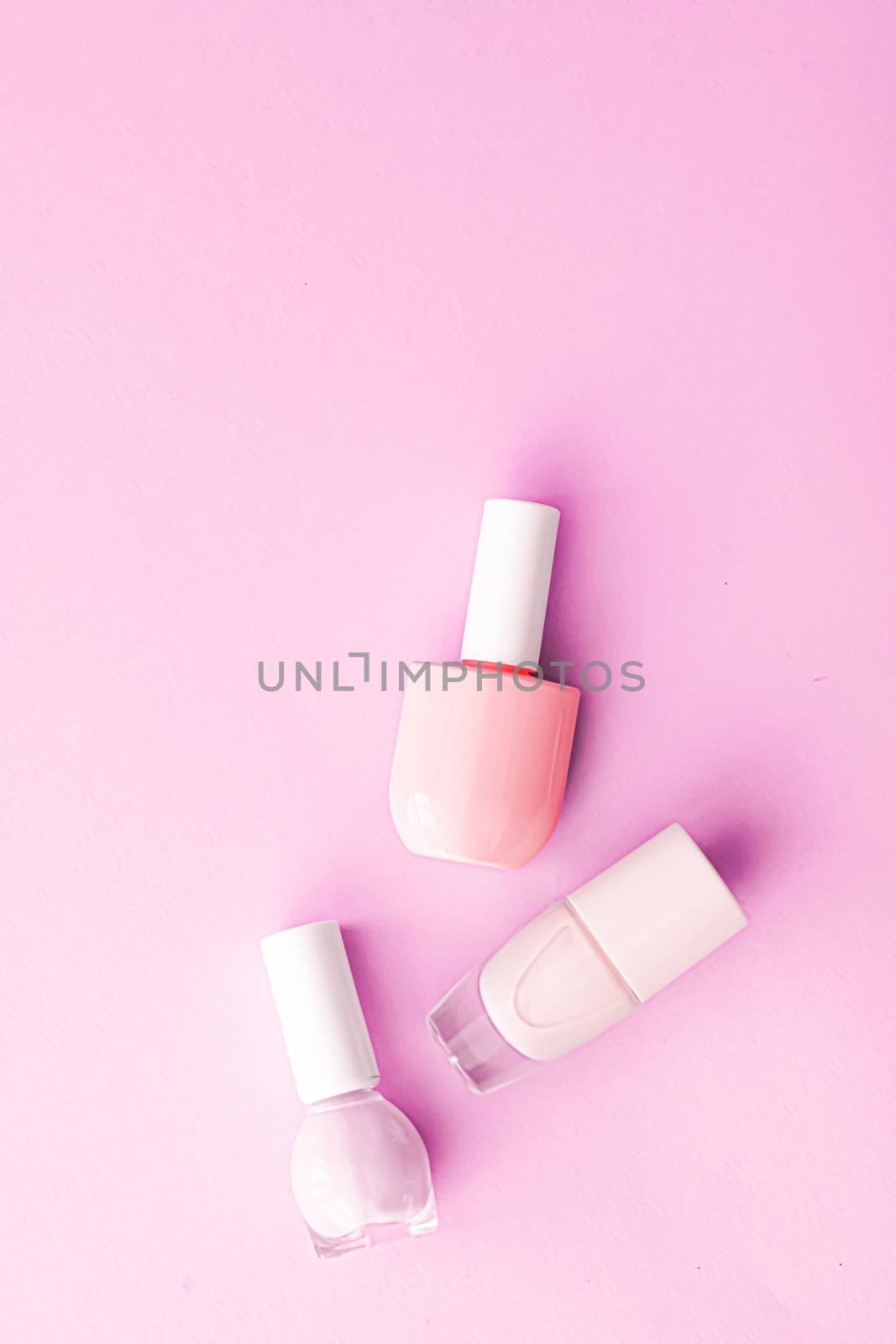 Nail polish bottles on pink background, beauty brand by Anneleven
