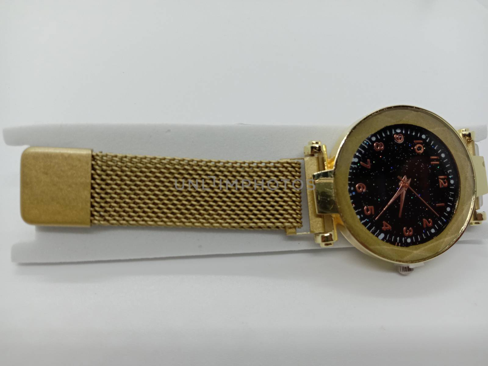 golden colored watch closeup on gray background