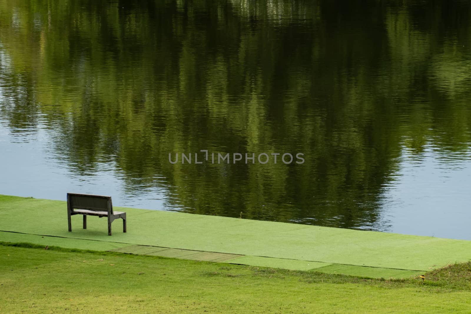 Wooden chair near river and green view.
