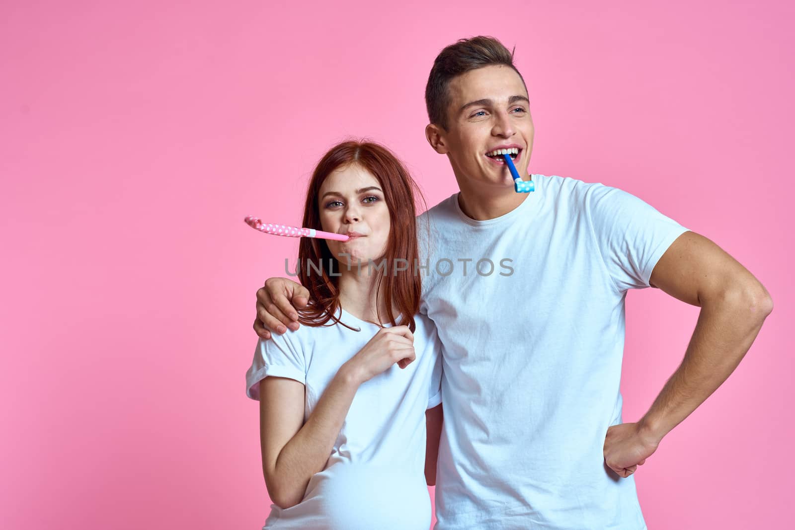 pregnant mom and happy father on pink background Young family waiting for baby. High quality photo