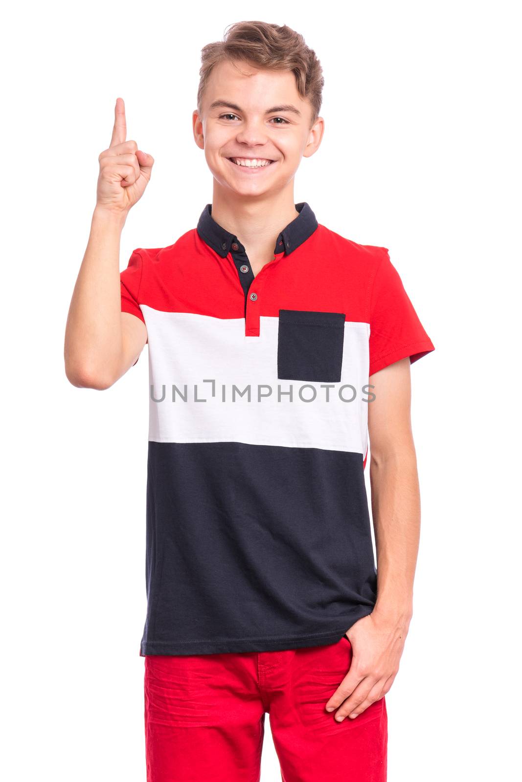 Portrait of happy teen boy pointing finger up at copy space, isolated on white background. Teenager pointing finger at something. Cute smiling child looking at camera.