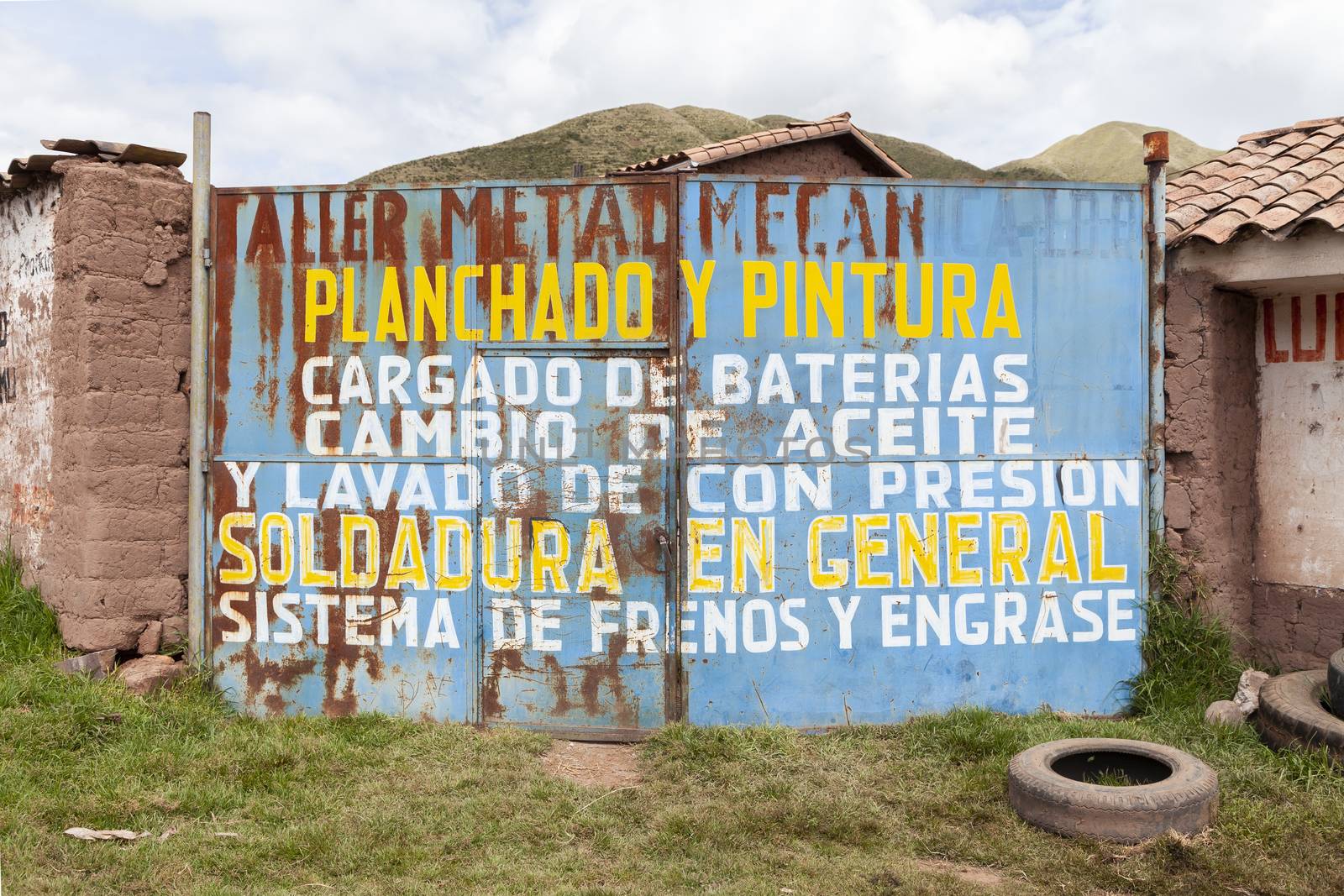 Ccorao, Peru - April 4, 2014: The rusty doors of an old car workshop on the road towards Taray and Pisac, Peru.