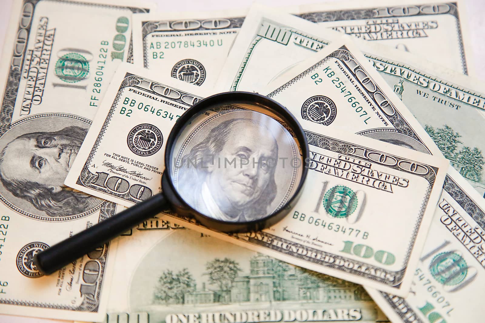 On the hundred dollar bills is a magnifying glass .Texture.Background.