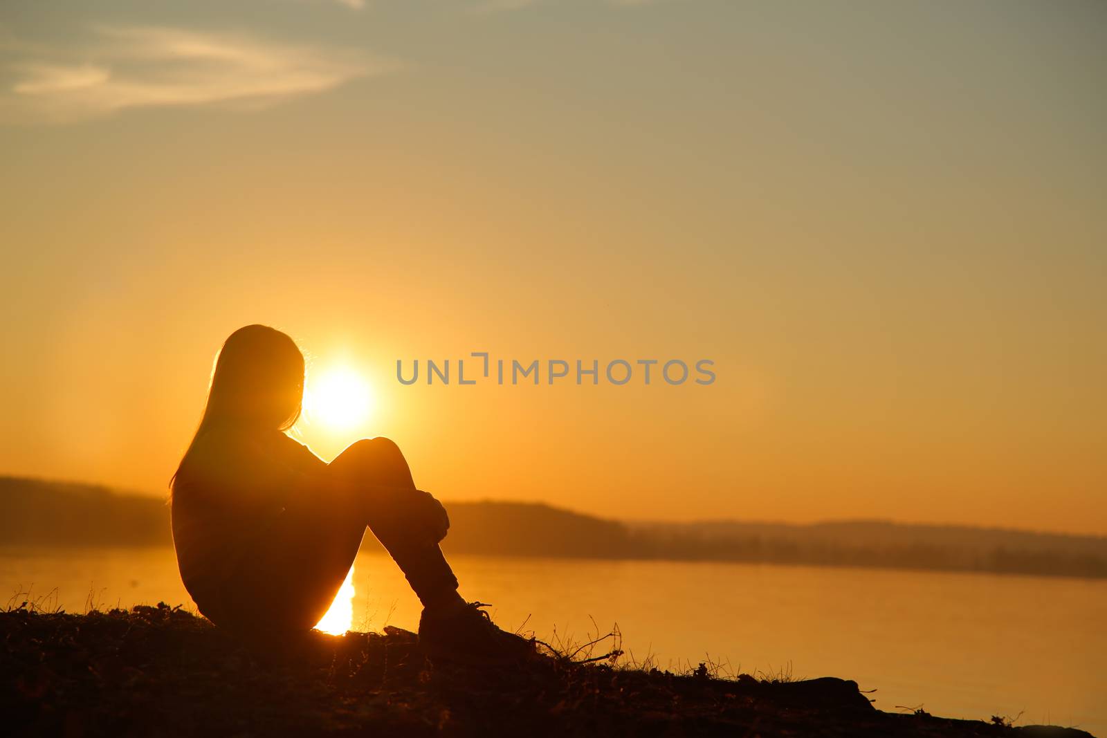 Teen sitting on the beach and watching the sunset by Mastak80