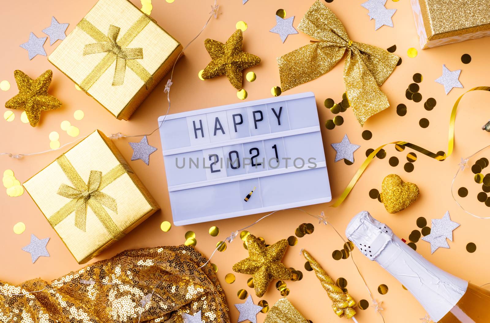 New Year and Christmas flat lay. Lightbox with the words Happy 2021 top view on yellow background with confetti and decorations flat lay