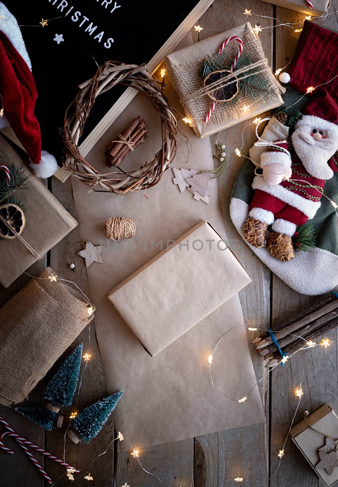 Zero waste and eco friendly christmas concept. Christmas holiday gift wrapped in craft paper on wooden background. Eco friendly products lay out on dark table