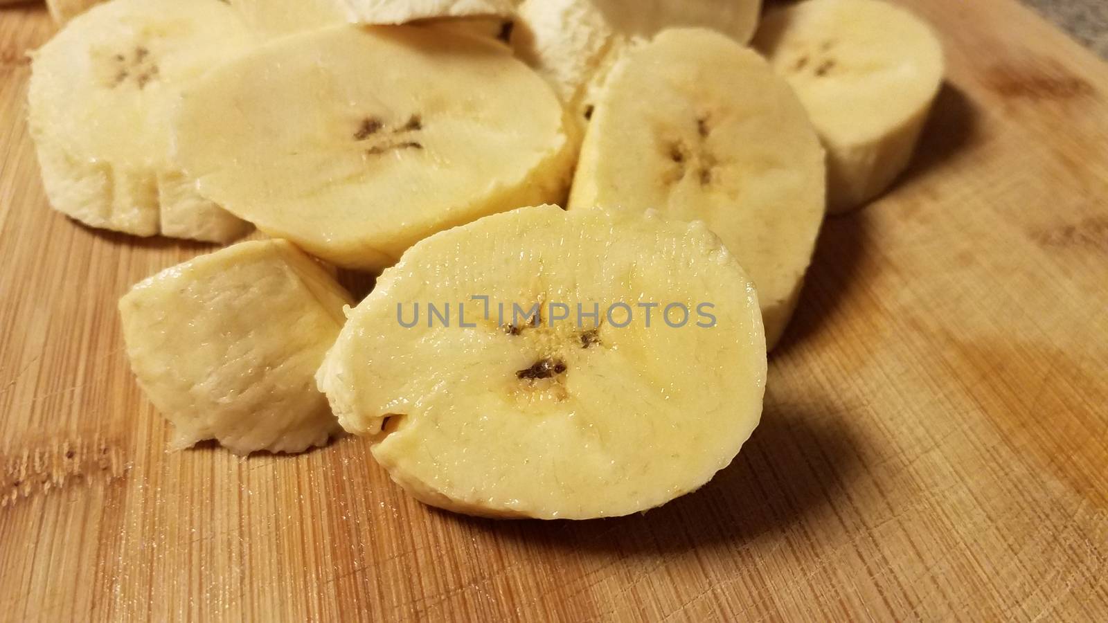 sliced plantain banana fruit on wood cutting board