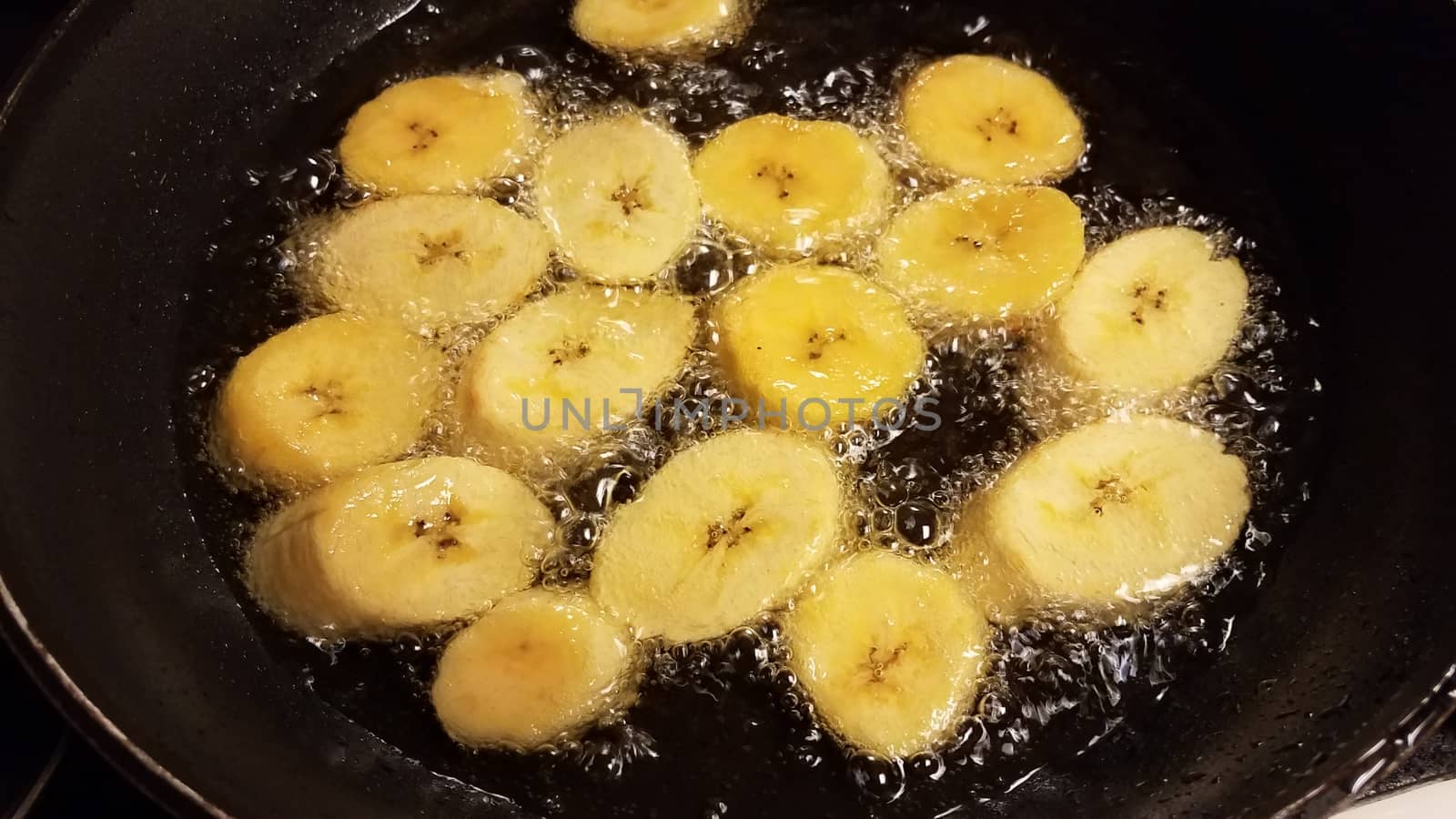 plantain banana from Puerto Rico boiling in oil in frying pan