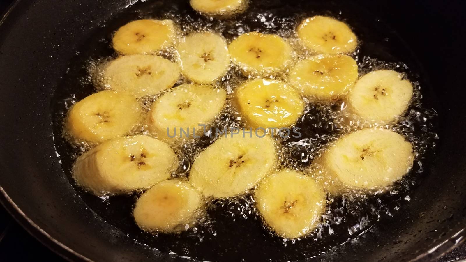 plantain banana from Puerto Rico boiling in oil in frying pan
