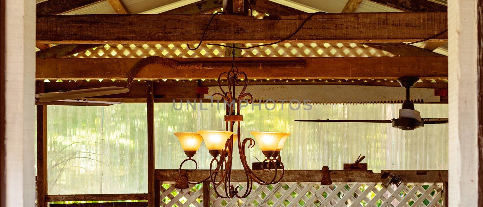 A Retro Chandelier Glowing Light In A Rustic Country Cafe by 	JacksonStock