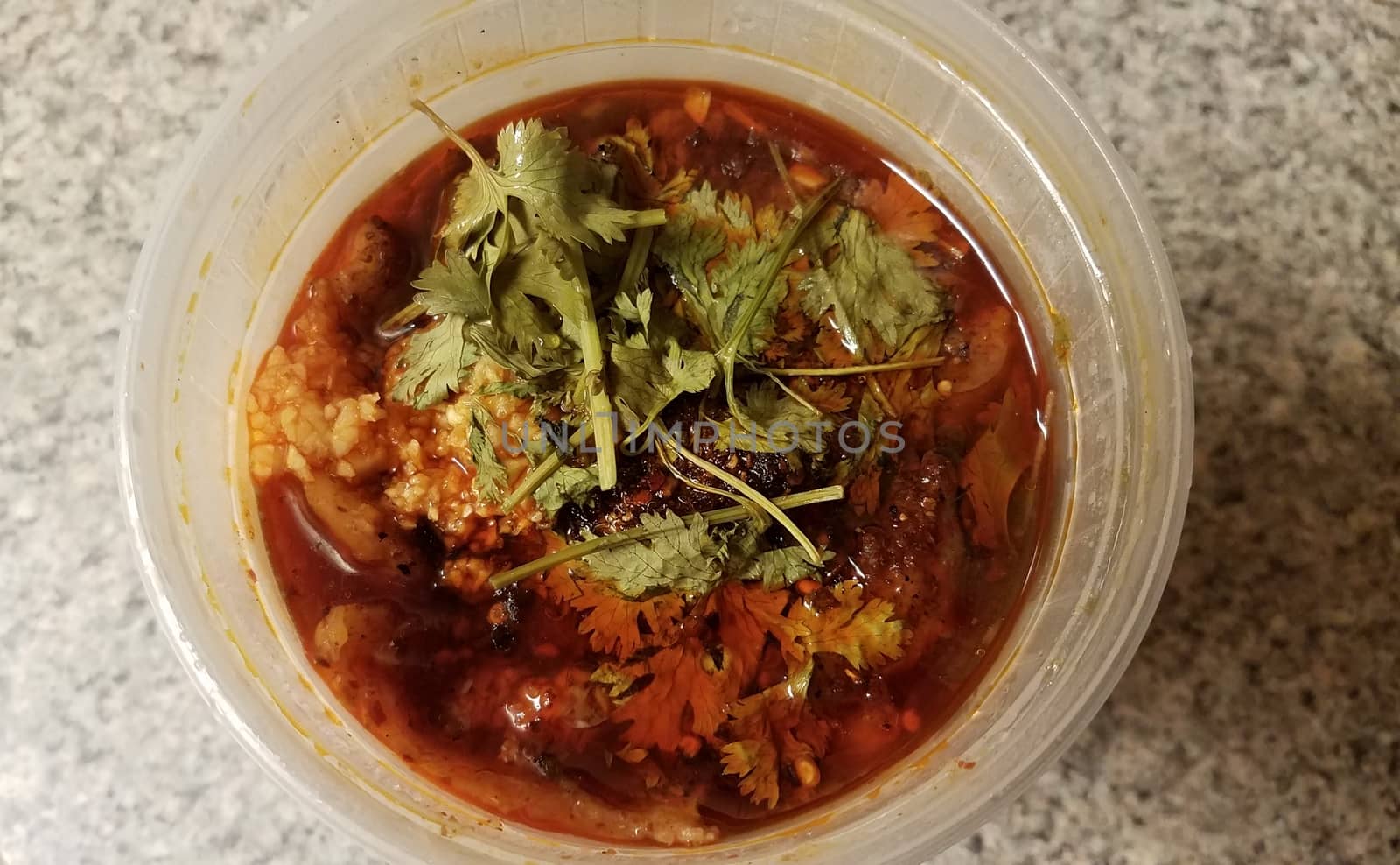 Chinese spicy fish and garlic in chili oil in plastic container