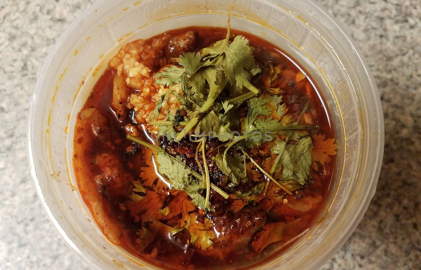 Chinese spicy fish and garlic in chili oil in plastic container