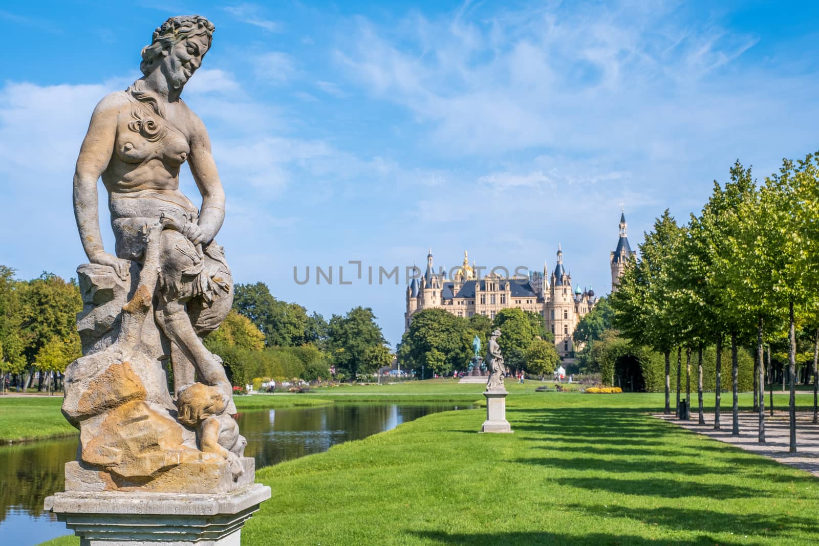 Alley of trees and statues in the Schwerin park.