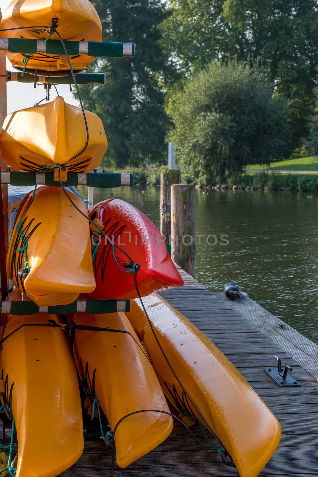 Colorful kayaks on the lake outdoor on a summer day by Fischeron