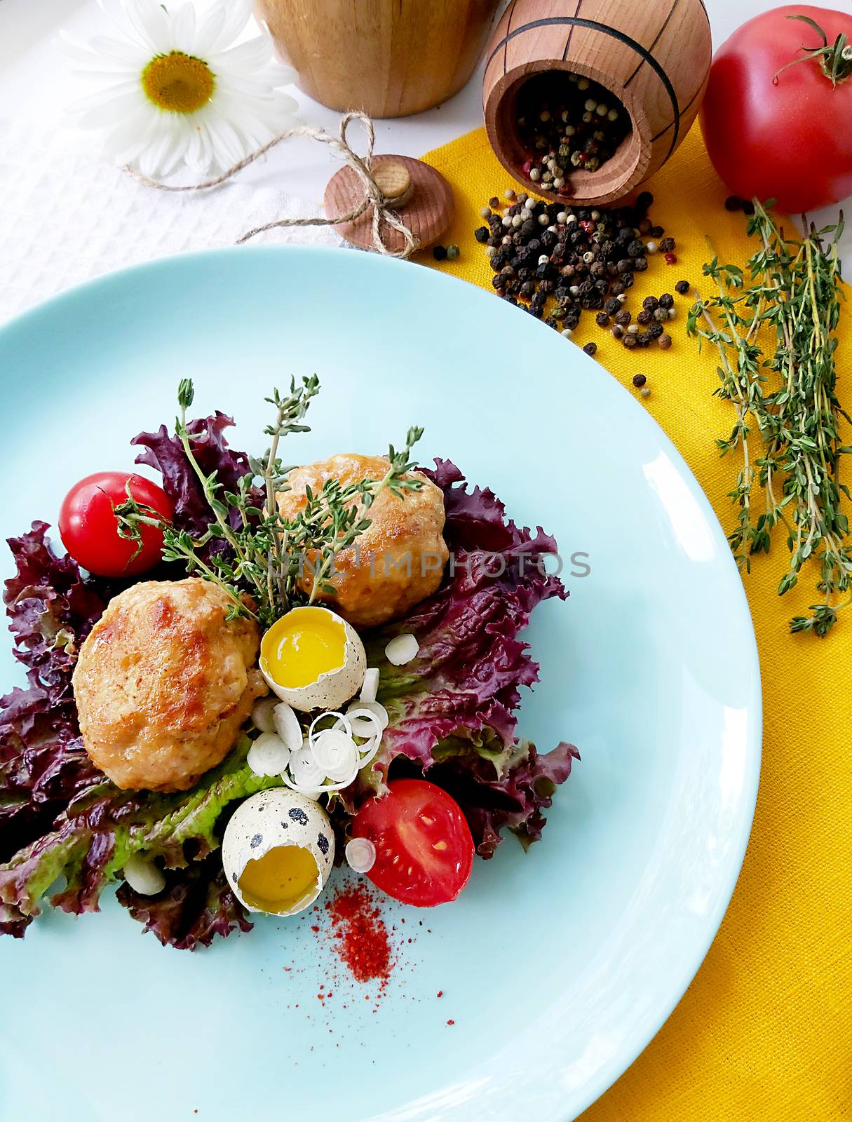 Fried cutlets with quail eggs garnished with herbs and tomatoes