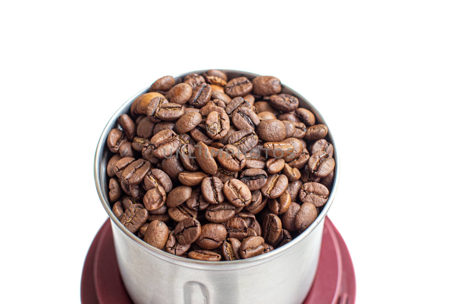 A lot of coffee beans in a metal coffee grinder on a white background. Isolated.