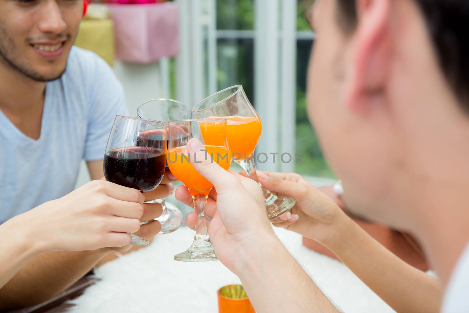 Asian group people drinking at party outdoor. group of friends cocktails in hand with glasses.close up on hand holding beverage.