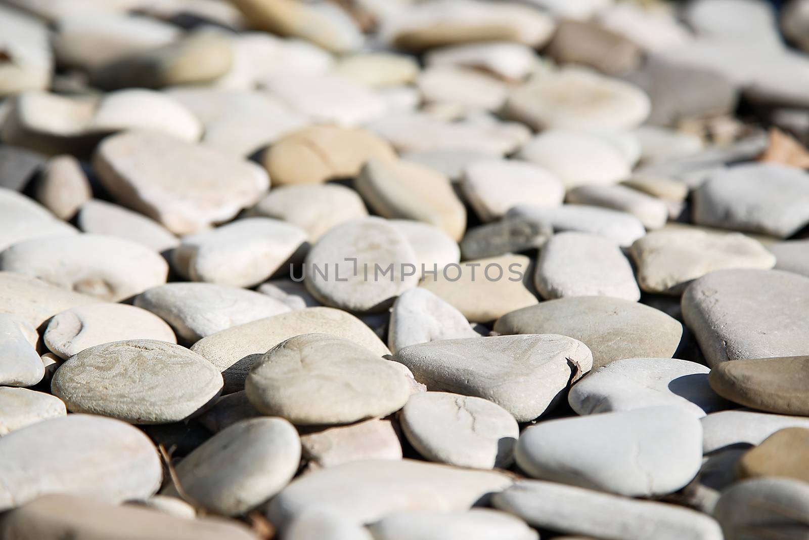 Out of focus pebbles on the beach closeup .Texture.Background.
