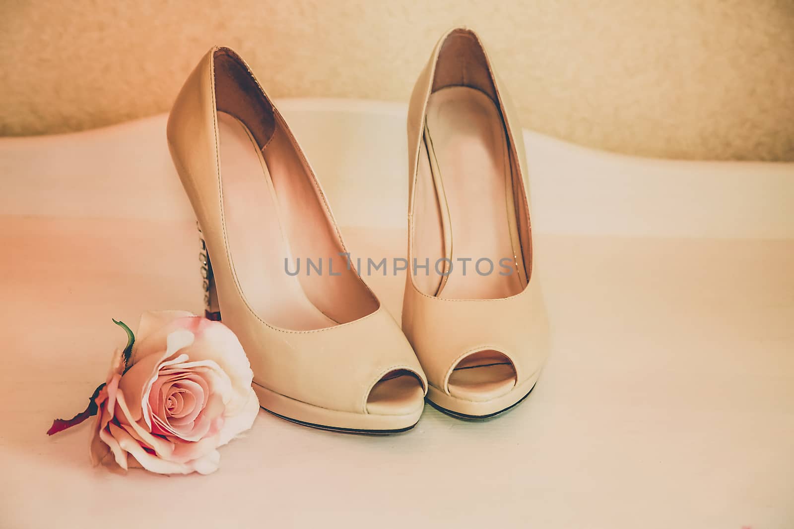 Wedding shoes beige high-heeled stand on the ladies ' table with a rosebud