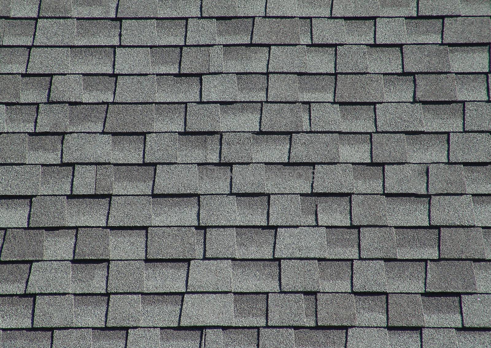 The roof is covered with soft shingles in the form of geometric plates of gray color.Texture and background.