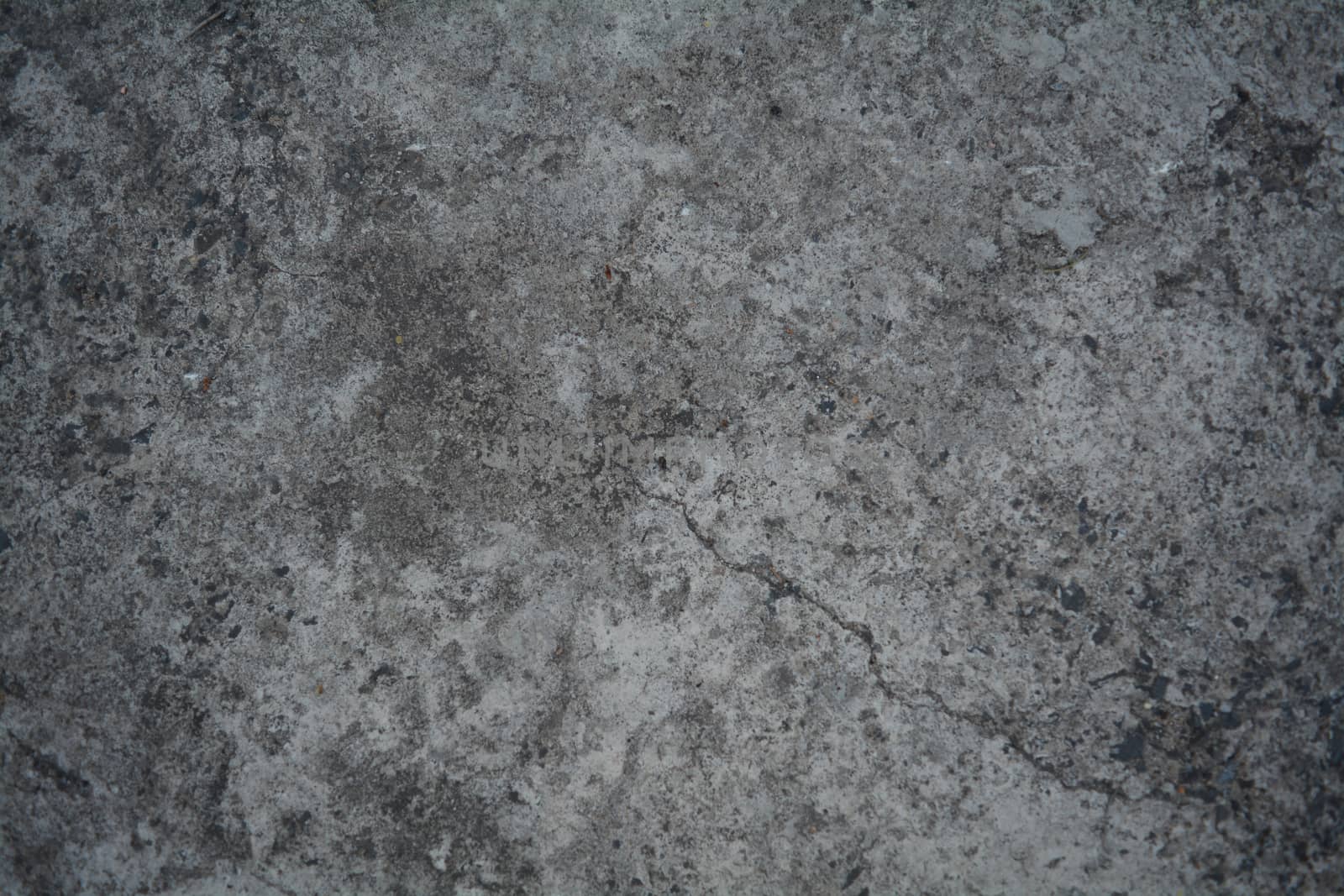 Texture of dark grey marble with a crack in the corner