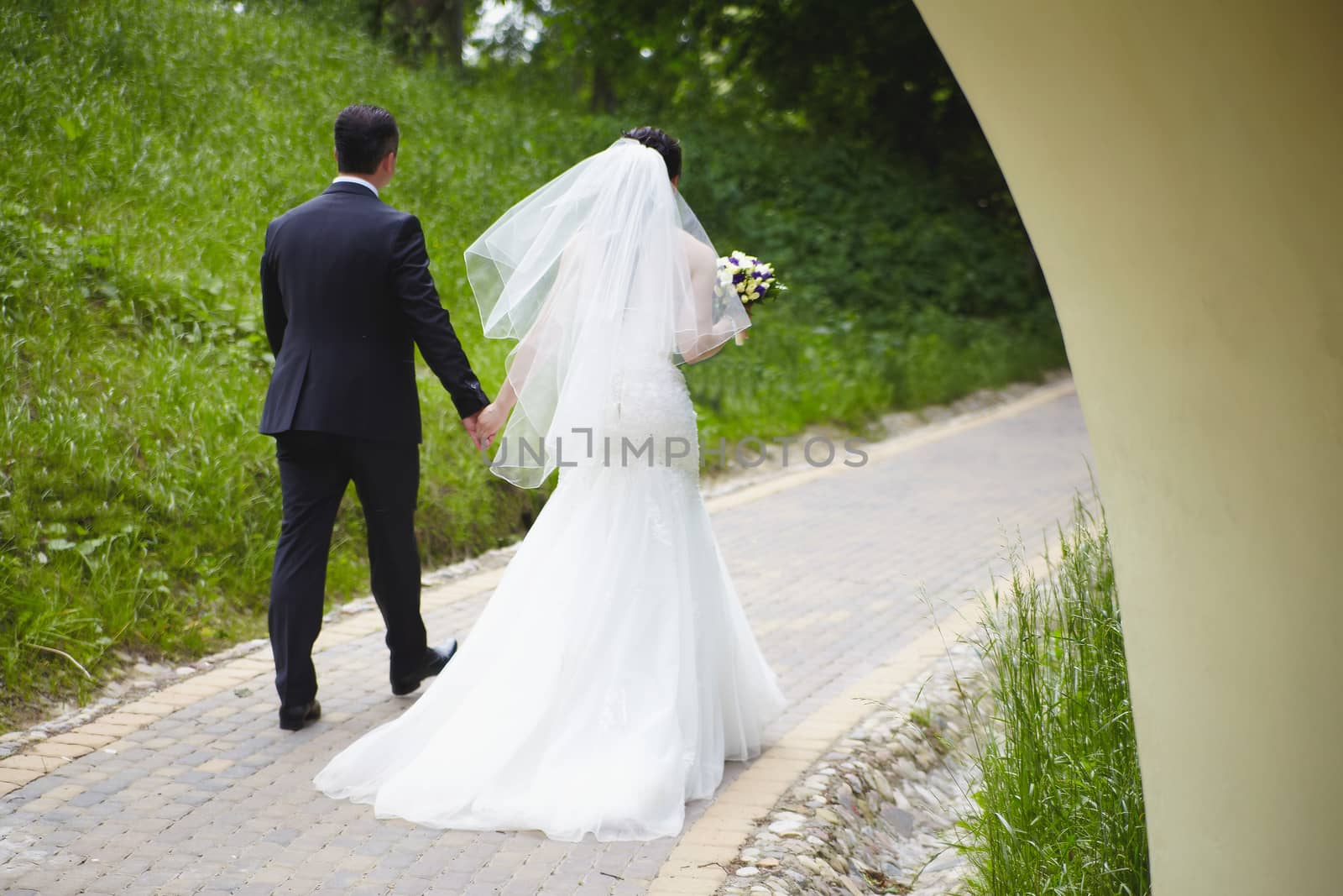 The bride and groom on the wedding day go forward holding hands