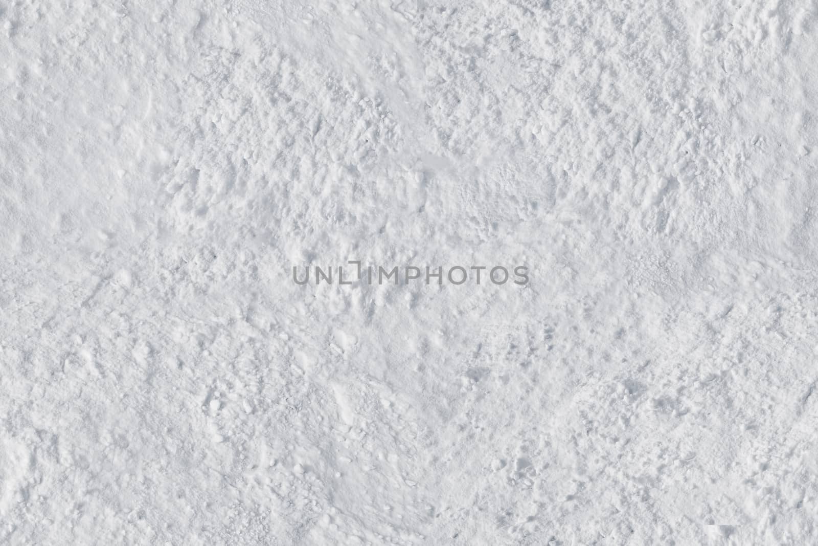 White snow close-up with an uneven rough surface .Texture or background