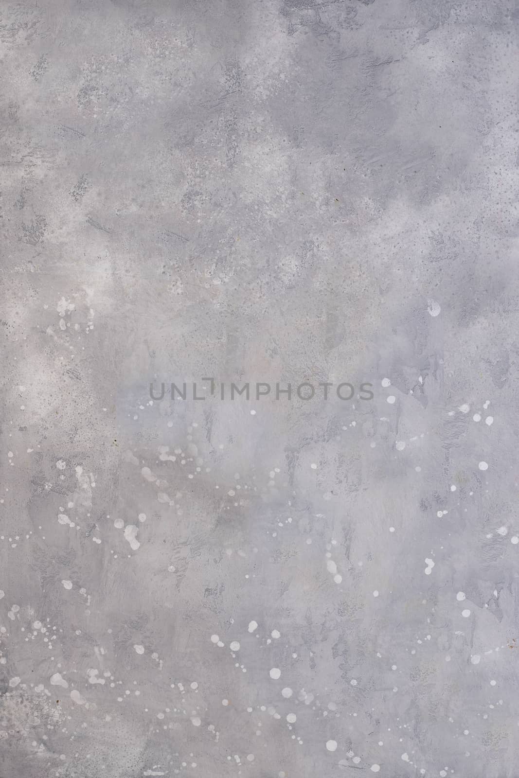 Grey wall with splashes on the surface of white acrylic paint .Texture or background.