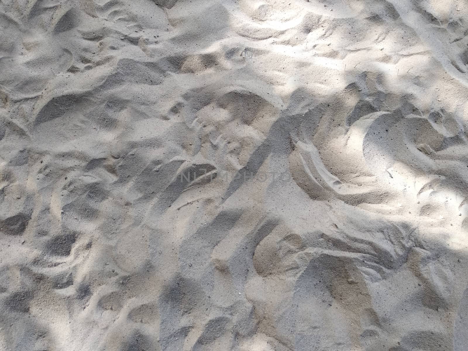 Natural background of sand texture with irregularities and depressions.