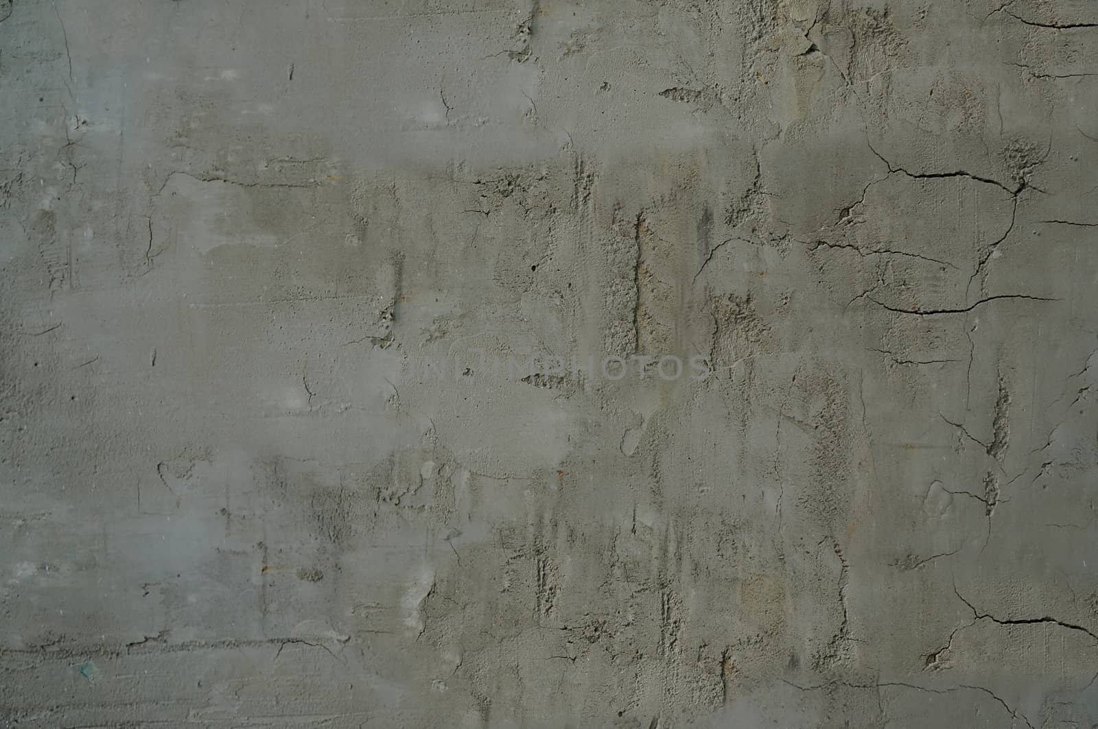 The wall without finishing is gray with cracks and irregularities on the surface .Texture or background