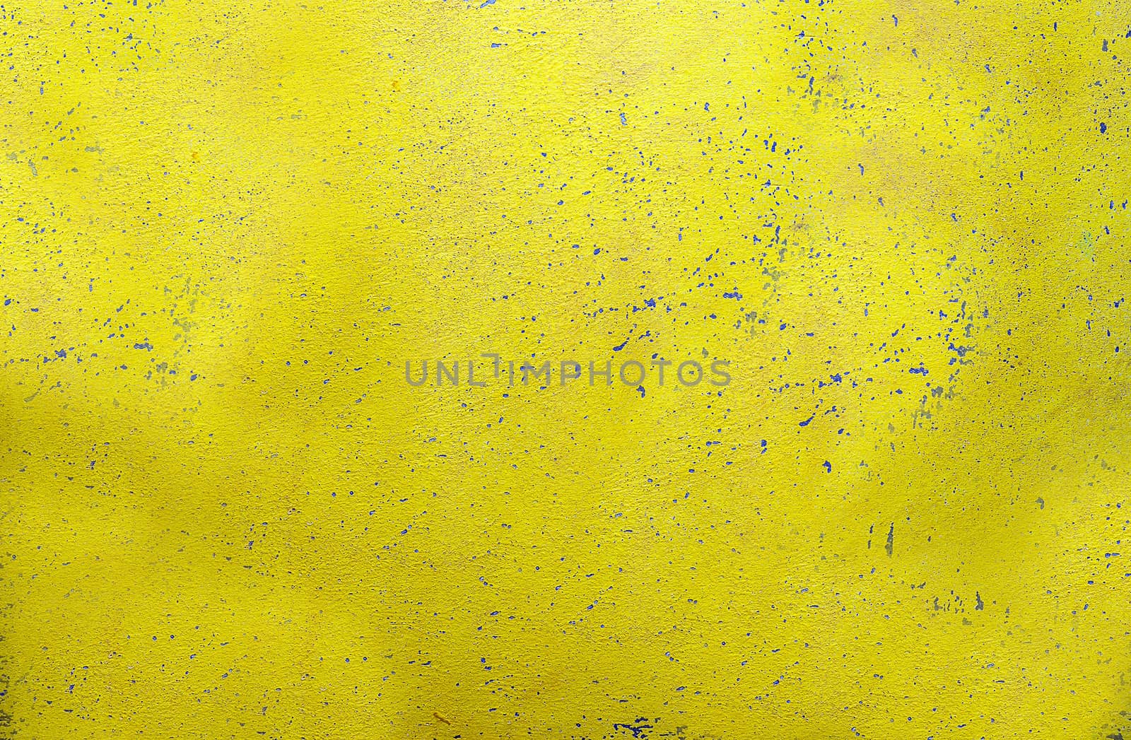 A wall with a textured, rough and scratched yellow surface.Texture or background