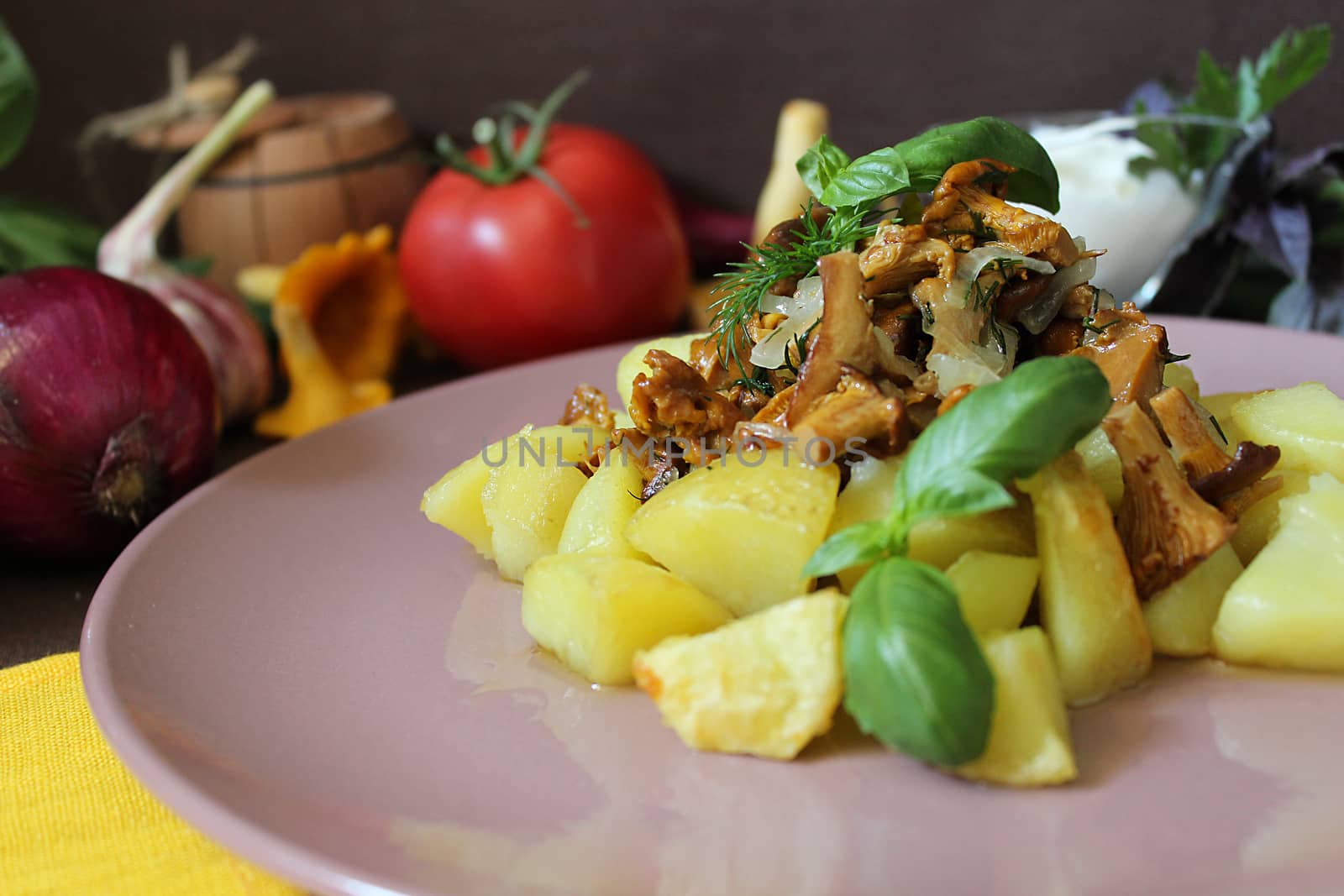 Fried potatoes with chanterelles on a plate and greens