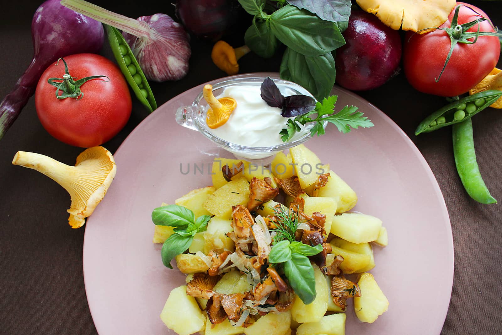 Close up of a plate with fried mushrooms vegetables and potatoes in a rustic way