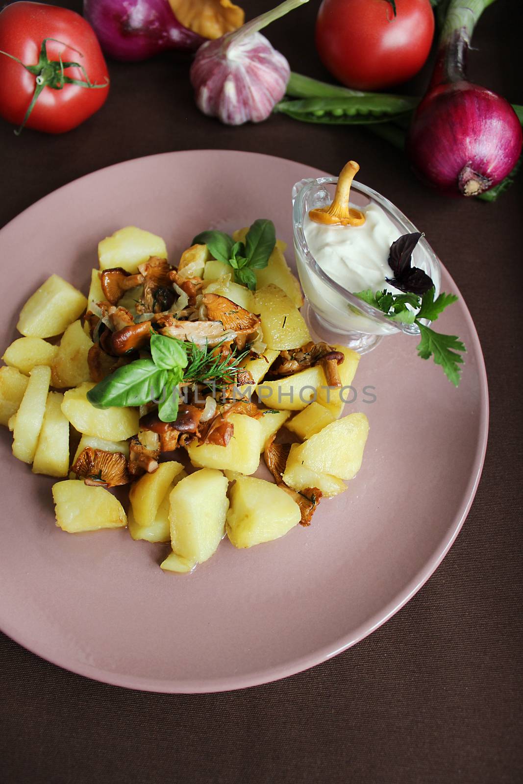 Fried potatoes with mushrooms with sauce and herbs close up