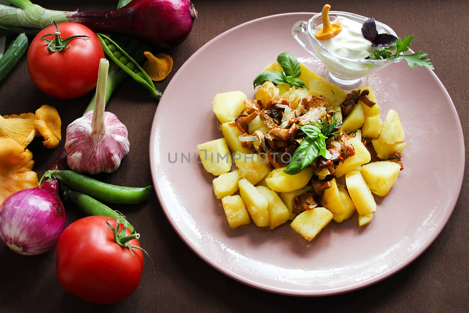 Close up on the table fried mushrooms with potatoes and vegetables