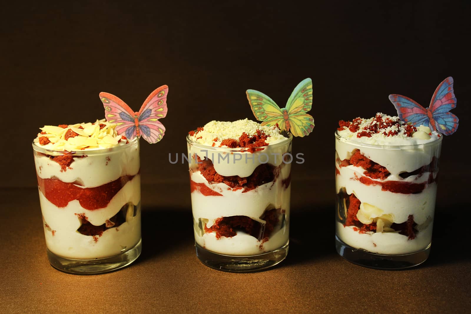 In a transparent container strawberry ice cream is decorated with a slice of strawberry