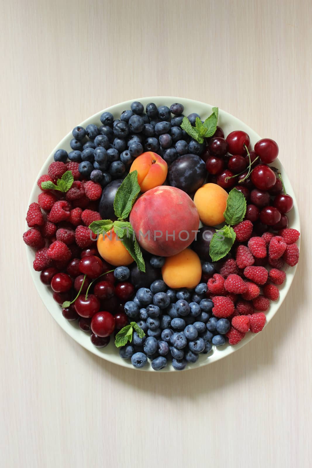 Mix of berries on the table on a white plate .Texture or background