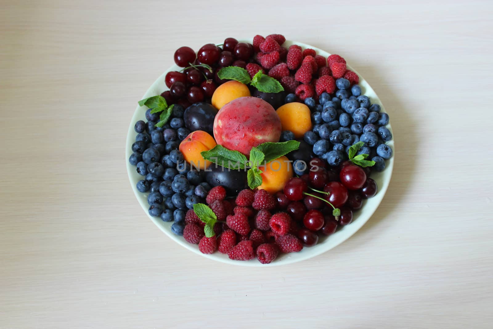 Berry mix on a plate on a white background.Texture or background