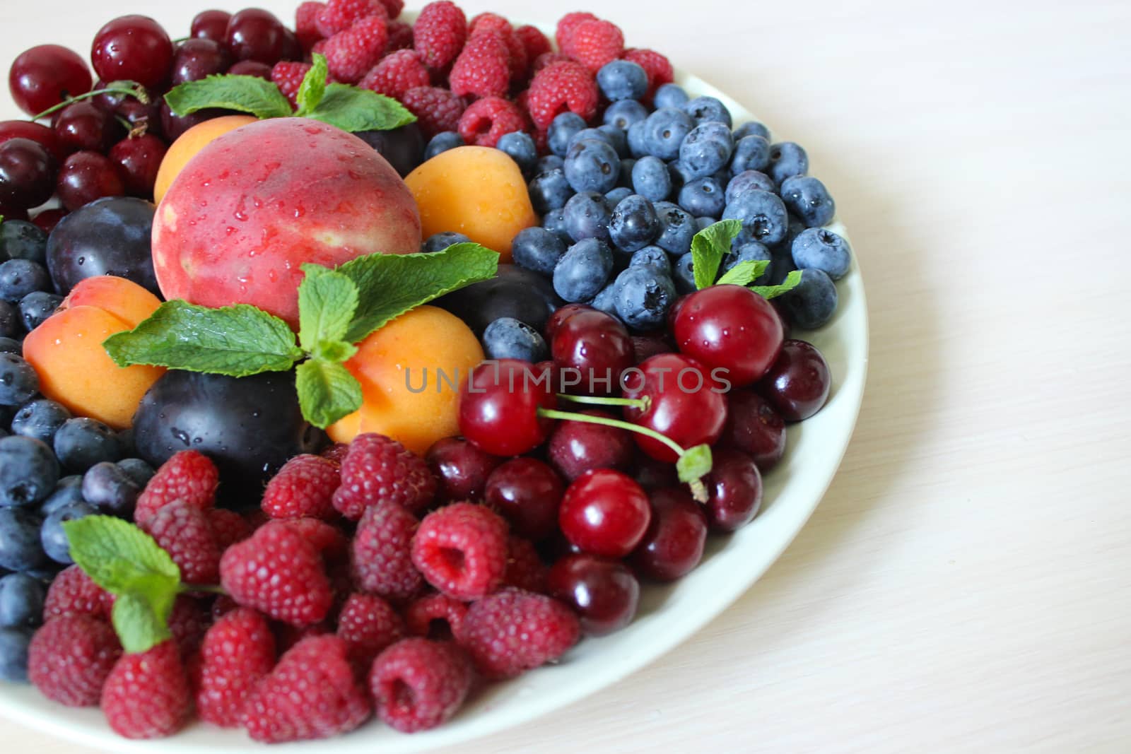 Summer mix of berries on a white plate .Texture or background