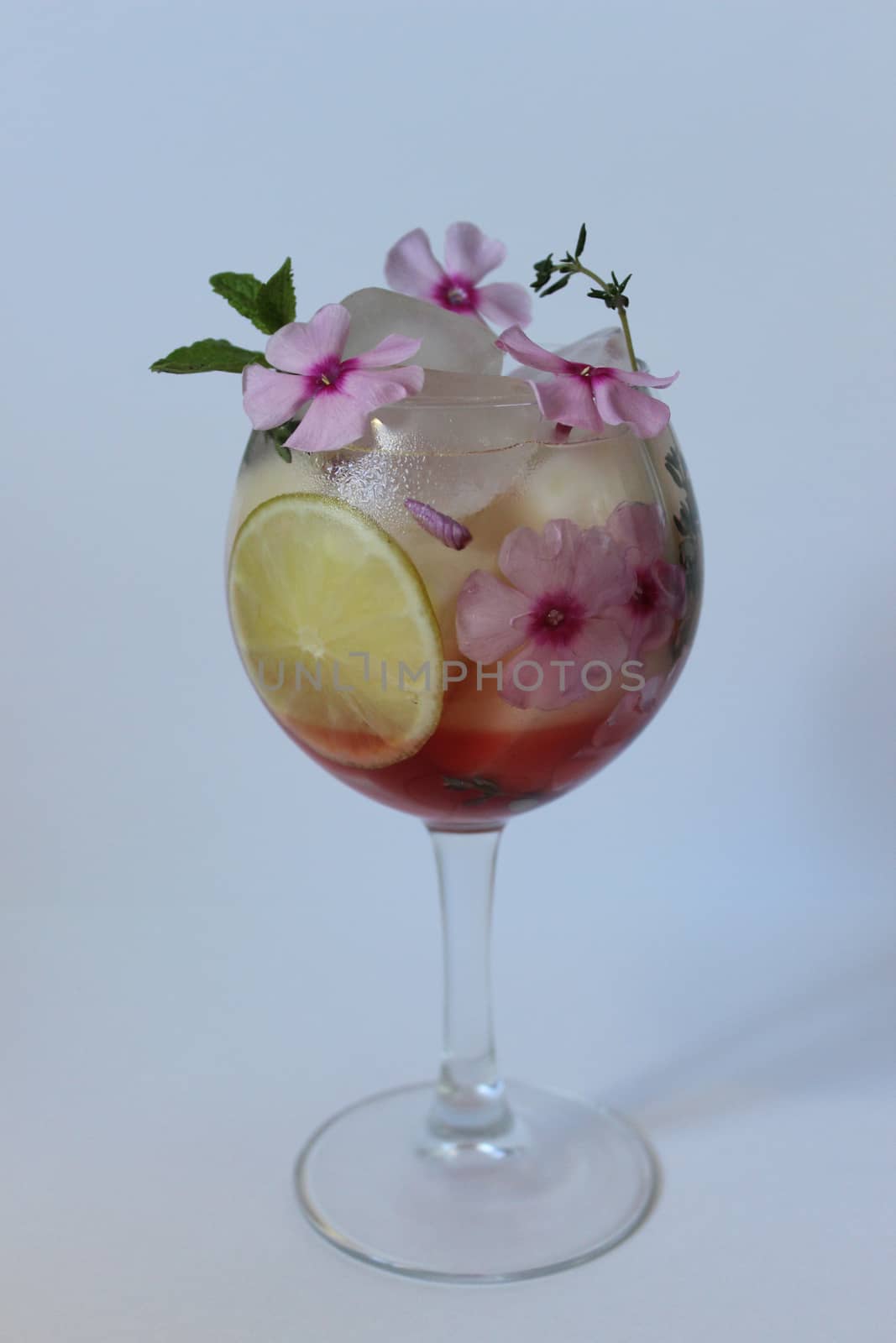 Cold fruit tea decorated with flower and mint.Texture or background