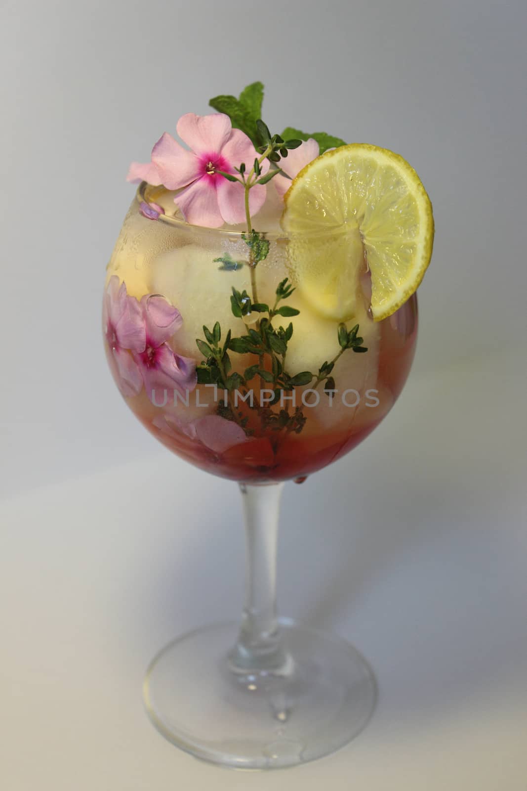 Fruit lemon tea with ice cubes and decorated with mint leaf close up