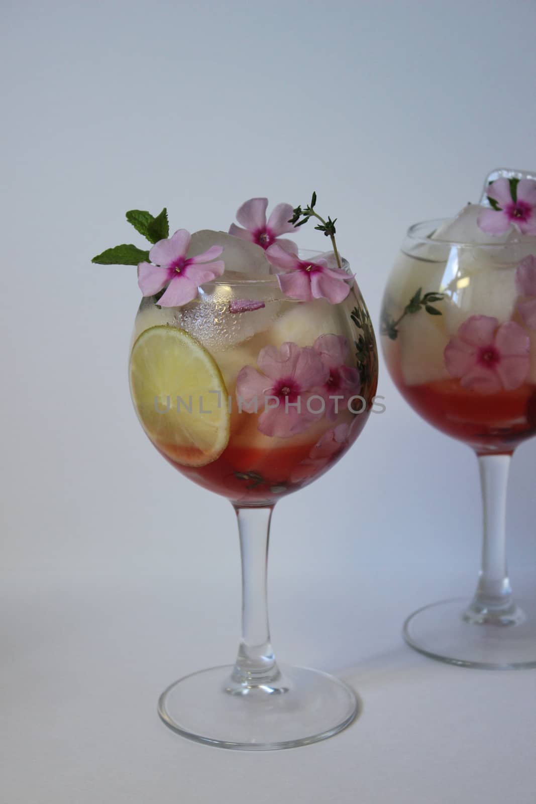Cold fruit tea decorated with flower and mint.Texture or background