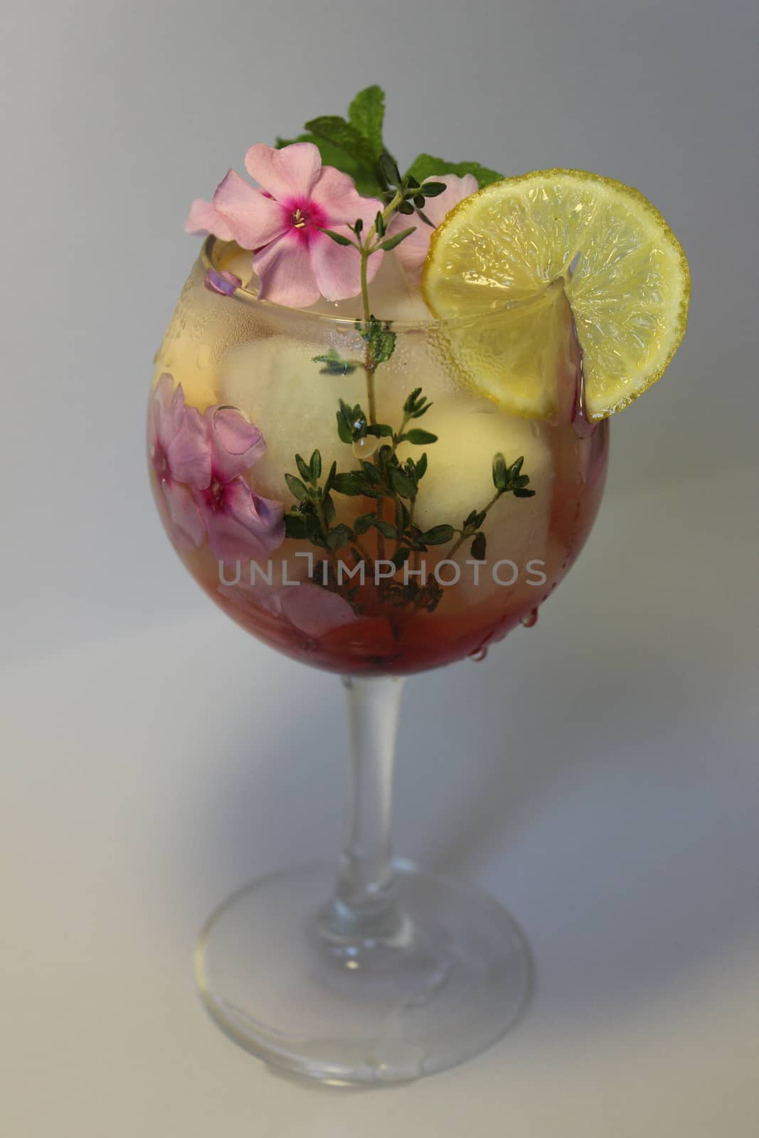 Refreshing homemade lemon juice with ice cubes and decorated with flowers