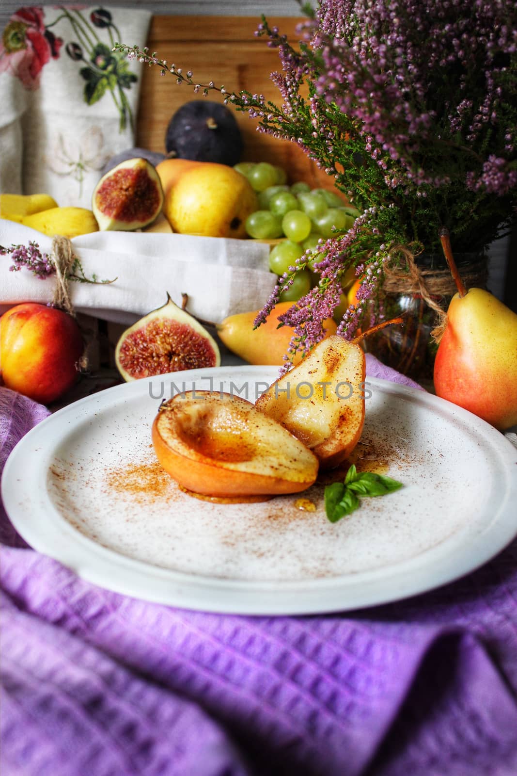Baked pears in syrup on a white plate with a mint leaf close-up.Texture or background
