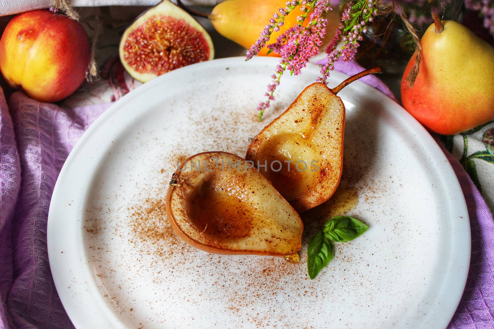 Fruit still life baked pears in syrup on a white plate with a mint leaf.Texture or background